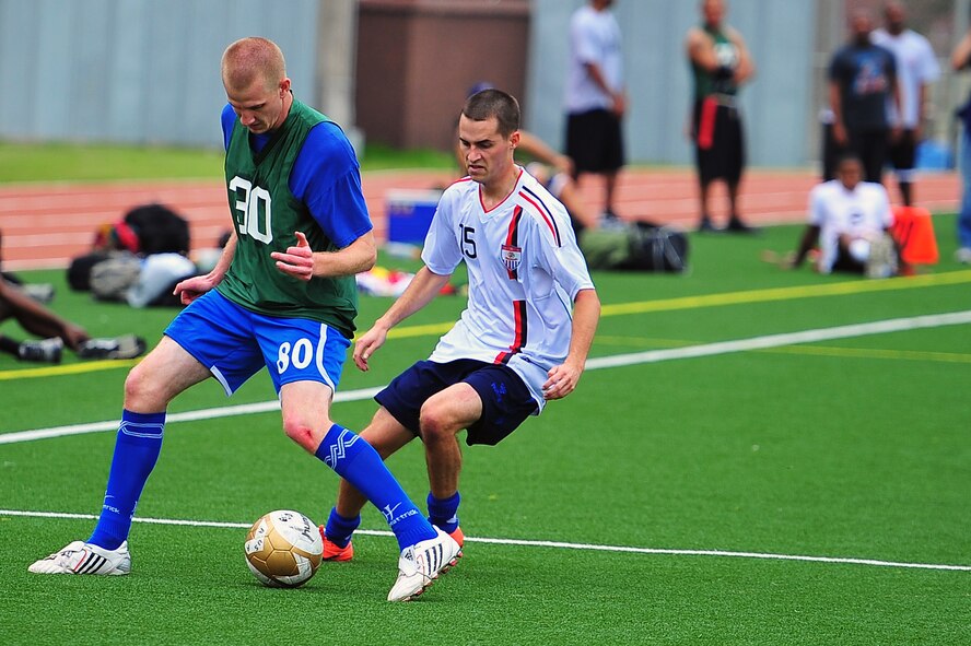 Senior Airman Joshua McMaster maneuvers a ball up-field in a soccer tournament as Specialist Travis Gilley plays tight defense during the 2012 Sports Day event held at Osan Air Base, Sept. 28, 2012. Yongsan took third in the day’s events by winning the dodge ball portion of the competition. Kunsan ranked second after winning in basketball, but Osan won overall in softball, football, soccer, bowling and volleyball. McMaster is a client systems technician with the 8th Communications Squadron and Gilley is a U.S. Army Soldier with the 142nd Military Police. (U.S. Air Force photo/Staff Sgt. Craig Cisek) 