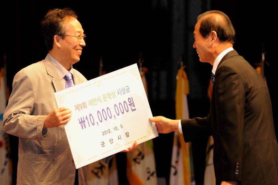 Dong-Shin Moon, right, mayor of Gunsan City, gives an author a check for 10 million Korean won (9000) for best novel at Gunsan City, Republic of Korea, Oct. 5, 2012. This award is only given out once per year and is a big honor to receive. (U.S. Air Force photo/Senior Airman Marcus Morris)