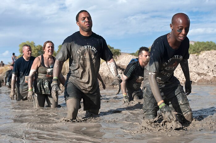 Senior Airman Michael Allen, 757th Aircraft Maintenance Squadron crew chief, and Senior Airman Kevin Wesley, 757th AMXS avionics specialist, walk across mud during the Tough Mudder obstacle course at Spicer Ranch Oct. 6, 2012, in Beatty, Nev. Airmen of the 757th AMXS ran the event as a team to help build camaraderie within their unit. (U.S. Air Force photo by Staff Sgt. Christopher Hubenthal)