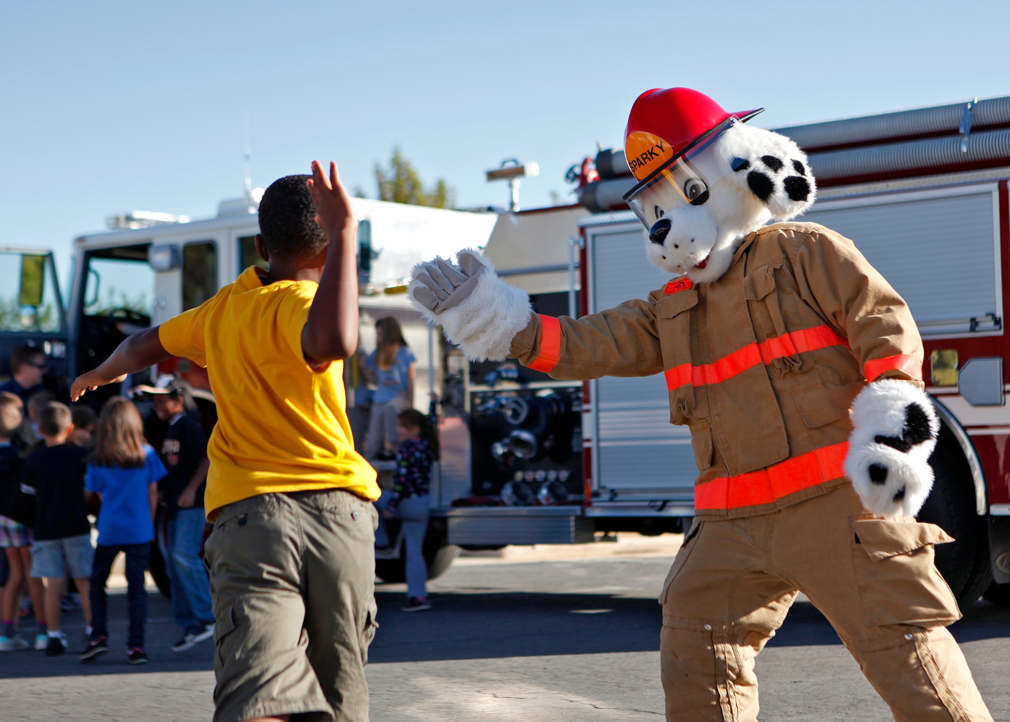 A Branch Elementary School student gives Sparky the Fire Dog a high five after completing his fire safety training Oct. 9 on the school grounds. The school was just one of many locations that will be visited by the Edwards Fire Department during Fire Prevention Week which runs from Oct. 7 to 13. (U.S. Air Force photo by Jet Fabara)