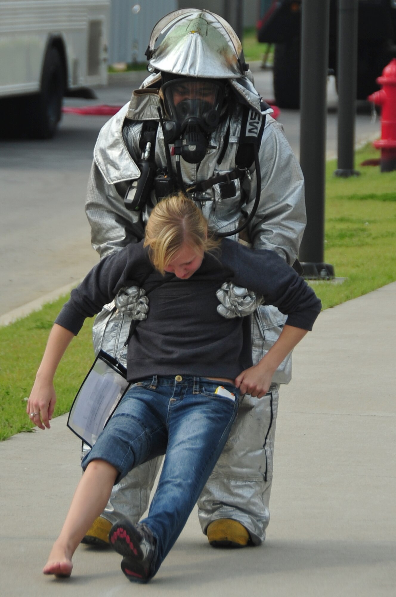 A firefighter from the 51st Civil Engineer Squadron performs a one-person drag on Airman 1st Class Alyssa Kelley during an emergency management exercise at Osan Air Base, Republic of Korea, Oct. 5, 2012. Kelley is a 51st Security Forces Squadron entry controller. (U.S. Air Force photo/Staff Sgt. Craig Cisek)