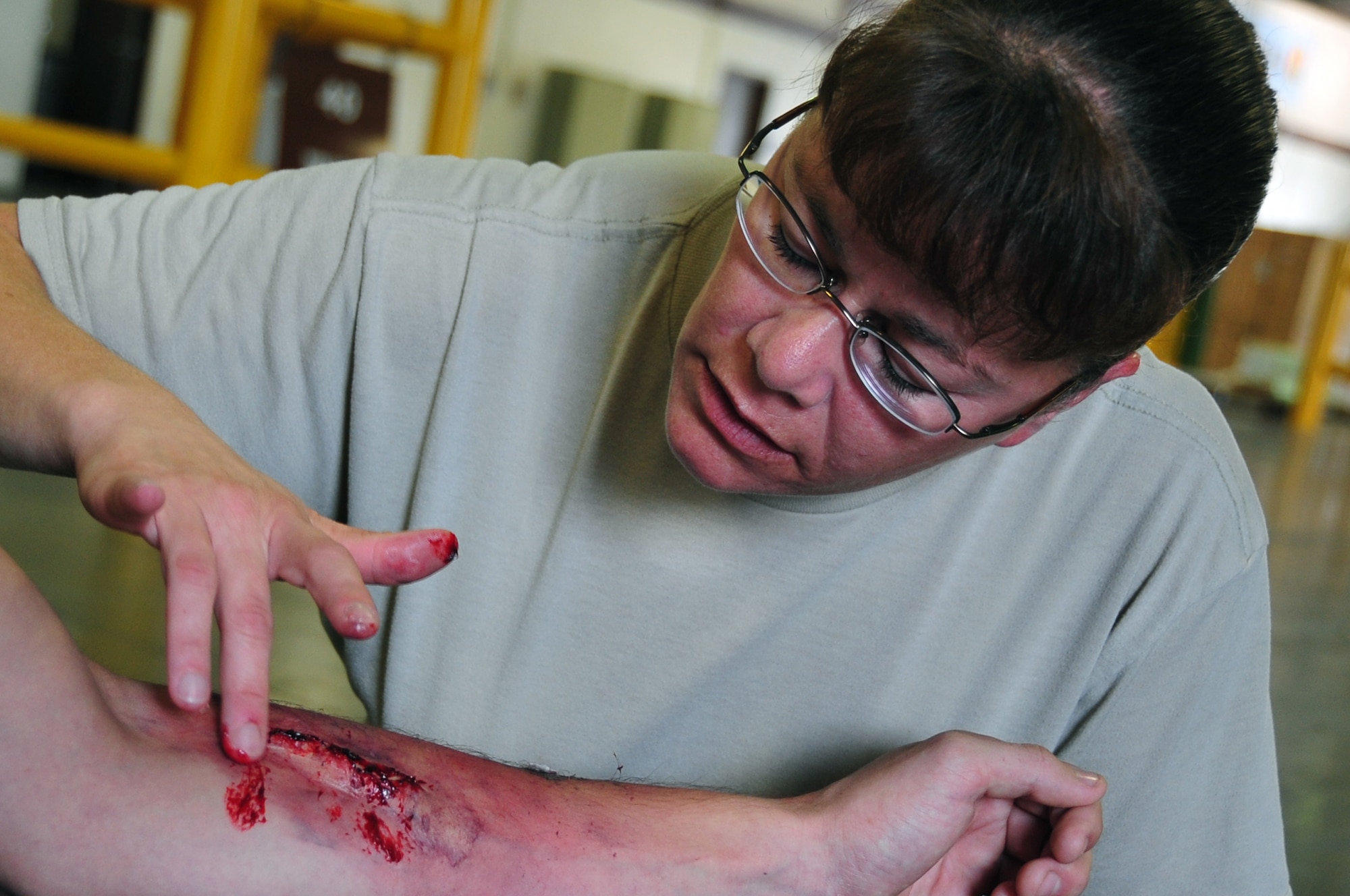 Senior Master Sgt. Tracey House, 51st Medical Support Squadron superintendent, applies moulage to simulate an arm injury before an emergency management exercise at Osan Air Base, Republic of Korea, Oct. 5, 2012. Participants exercised the ability to respond to a major incident at locations on and off base. Moulage adds realism to scenarios encountered by first responders. (U.S. Air Force photo/Staff Sgt. Craig Cisek)