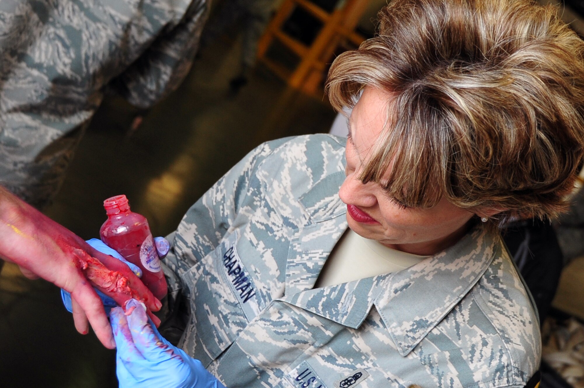 Senior Master Sgt. LaRae Chapman, 51st Dental Squadron superintendent, applies moulage to simulate a hand injury before an emergency management exercise at Osan Air Base, Republic of Korea, Oct. 5, 2012. Participants exercised the ability to respond to a major incident at locations on and off base. Moulage adds realism to scenarios encountered by first responders. (U.S. Air Force photo/Staff Sgt. Craig Cisek)