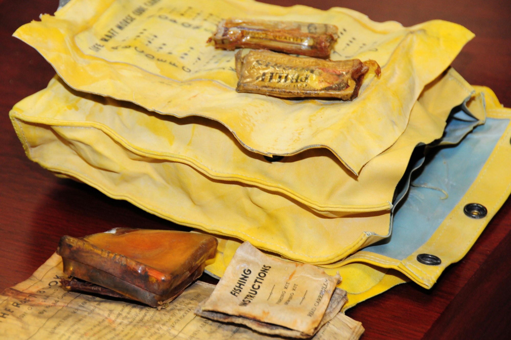 JOINT BASE ELMENDORF-RICHARDSON, Alaska -- Items recovered from the C-124 recovery site included survival equipment, desalinization kits, Morse code card, and a fishing kit with instructions. Artifacts like these and many others items were displayed for Tonja Anderson during her Sept. 28 visit here to learn about the 1952 crash that claimed the life of her grandfather and 51 other passengers. The aircraft wreckage was recently discovered on Colony Glacier, 14 miles south of the original crash site on Mt. Gannett. (U.S. Air Force photo/Master Sgt. Mikal Canfield)