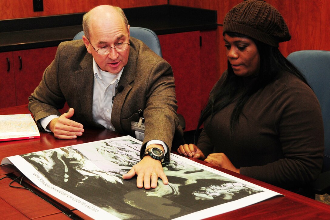 JOINT BASE ELMENDORF-RICHARDSON, Alaska -- Donald Jurewicz, Joint Task Force-Alaska deputy director for operations, explains details of the C-124 crash site to Tonja Anderson during her visit here Sept. 28, 2012.  Anderson was in Alaska to learn about the 1952 crash that claimed the life of her grandfather and 51 other passengers. The aircraft wreckage was recently discovered on Colony Glacier, 14 miles south of the original crash site on Mt. Gannett.  During her visit, Anderson was able to view items recovered from the site.  (U.S. Air Force photo/Master Sgt. Mikal Canfield)