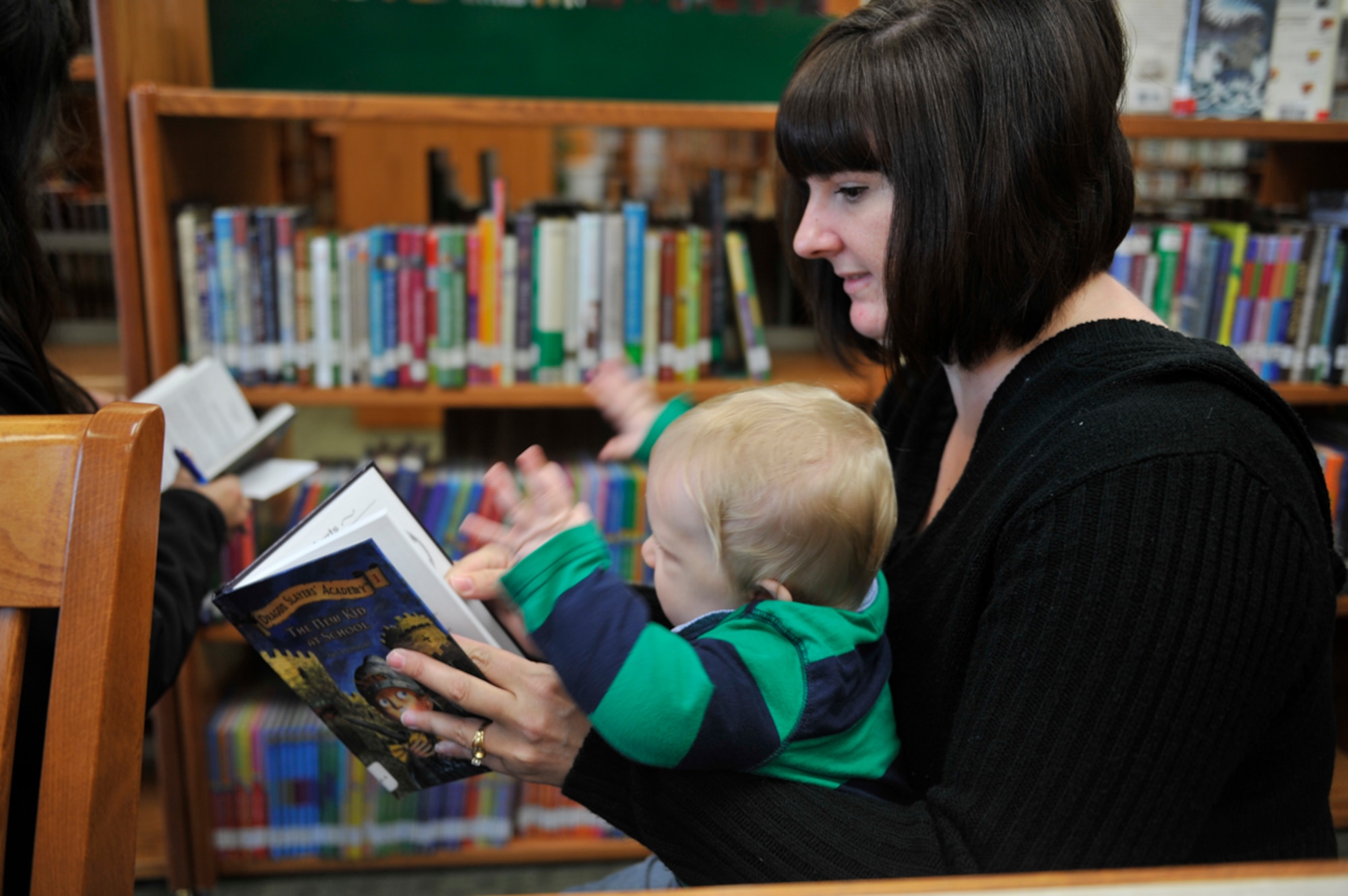 JOINT BASE ELMENDORF-RICHARDSON, Alaska -- Misti Woodruff and her son, Hikam, take advantage of the library's re-opening and browse for family friendly reading material. The library has broadened its selection since the remodeling. The library is a part of the JBER-Richardson Education Center which features classes and programs for online, college and  mission readiness training. (U.S. Air Force photo/ Airman Ty-Rico Lea)
