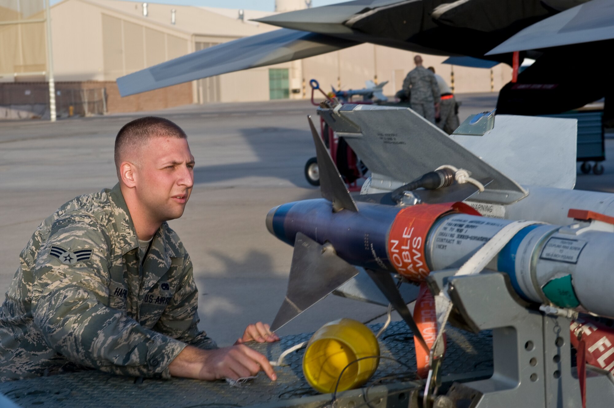 U.S. Air Force Senior Airman Lewis Hafner, 57th Aircraft Maintenance Squadron Raptor Aircraft Maintenance Unit weapons load crew member, inspects an AIM-120 advanced medium-range air-to-air missile, which is an air-interception missile, during a quarterly load crew competition Oct. 5, 2012, at Nellis Air Force Base, Nev. Weapons load teams are evaluated for use of the checklist, safety, and overall speed. (U.S. Air Force photo by Airman 1st Class Matthew Lancaster)
