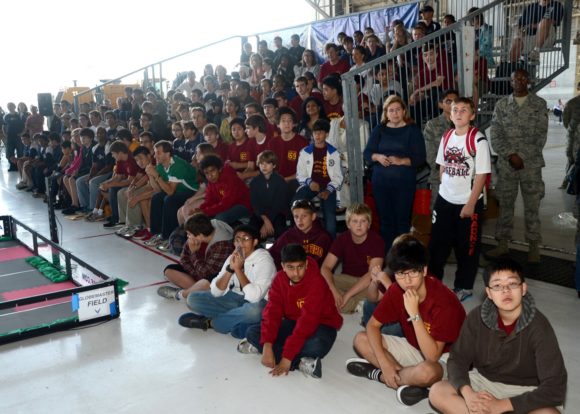 Competitors and spectators listen to the opening ceremony of the Delaware State VEX Championship Oct. 6, 2012, at Hangar 706 on Dover Air Force Base, Del. 37 teams from Delaware, Pennsylvania, New Jersey and Maryland competed. (U.S. Air Force photo by Tech. Sgt. Chuck Walker)