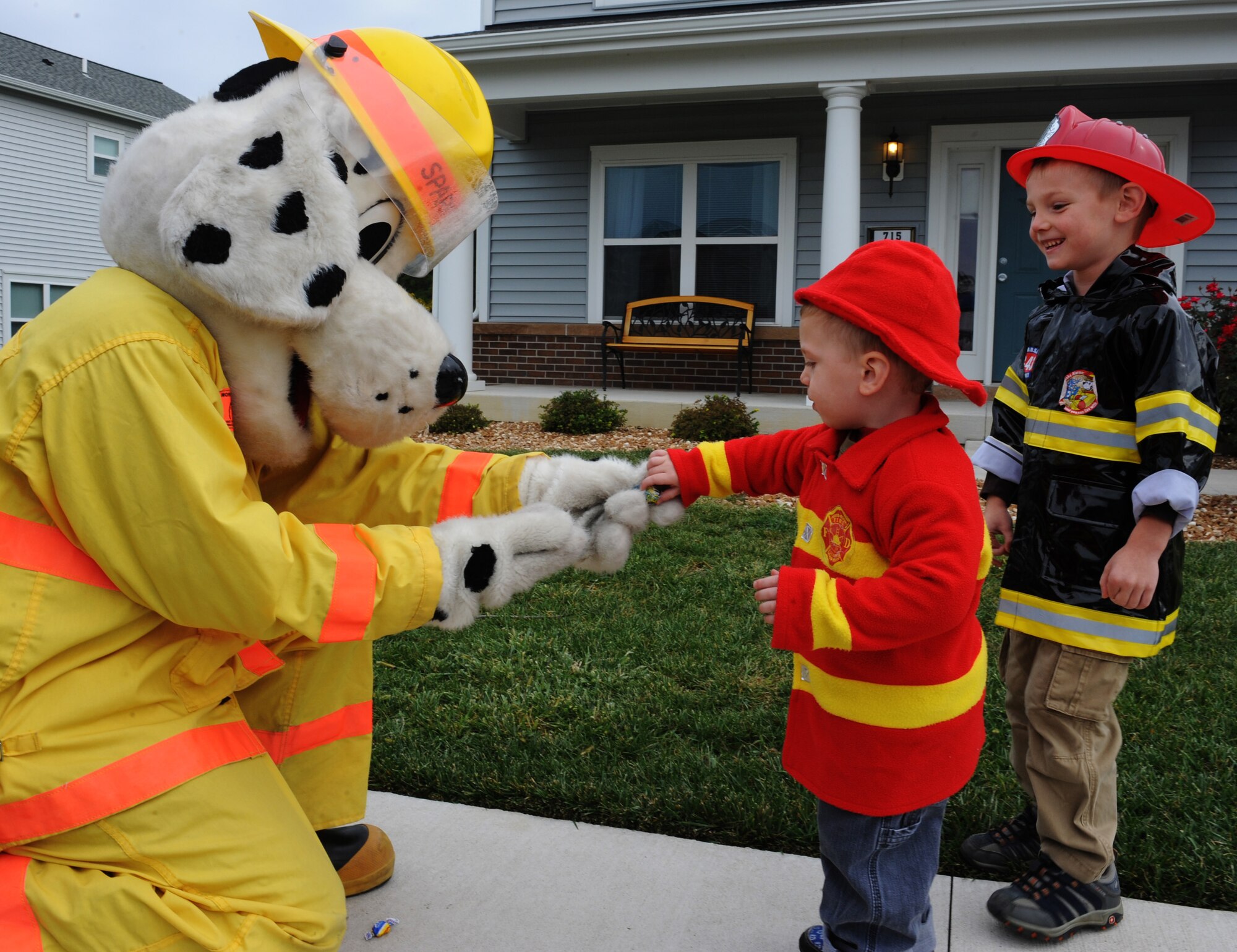 WHITEMAN AIR FORCE BASE, Mo. -- Sparky the Fire Dog hands out candy to children during a parade through base housing. Children lined the streets to see Sparky and Smokey The Bear, along with fire trucks from Whiteman and other local communities. (U.S. Air Force photo/Airman 1st Class Bryan Crane) (Released)