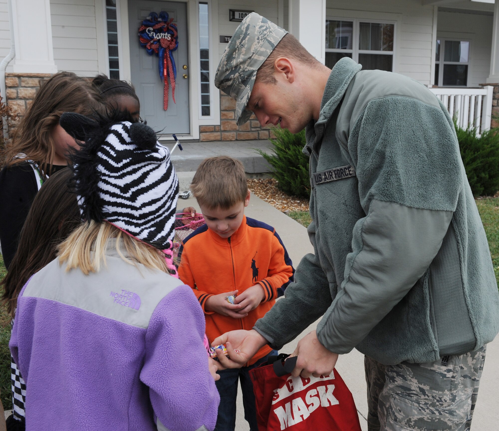 WHITEMAN AIR FORCE BASE, Mo. -- Airman 1st Class Kyle Lawall, 509th Civil Engineer firefighter, hands out candy during a parade through base housing, Oct. 6. The parade included fire trucks from Whiteman and other local communities. (U.S. Air Force photo/Airman 1st Class Bryan Crane) (Released)