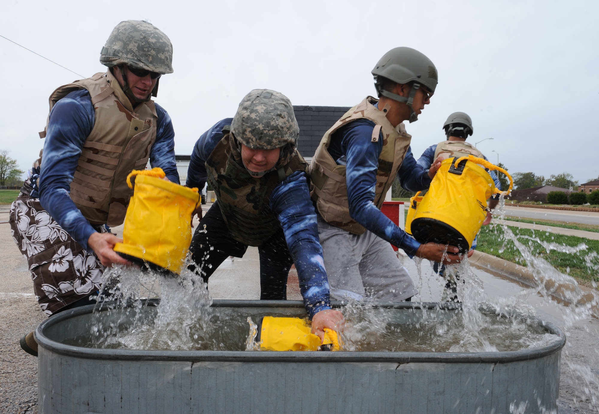 WHITEMAN AIR FORCE BASE, Mo. -- Members of the Wolfpack Fire Muster team, fill up buckets during the Bucket Brigade challenge, Oct. 6. The Wolfpack had the fastest time in the event and won the Overall Fire Muster challenge. (U.S. Air Force photo/Airman 1st Class Bryan Crane) (Released)