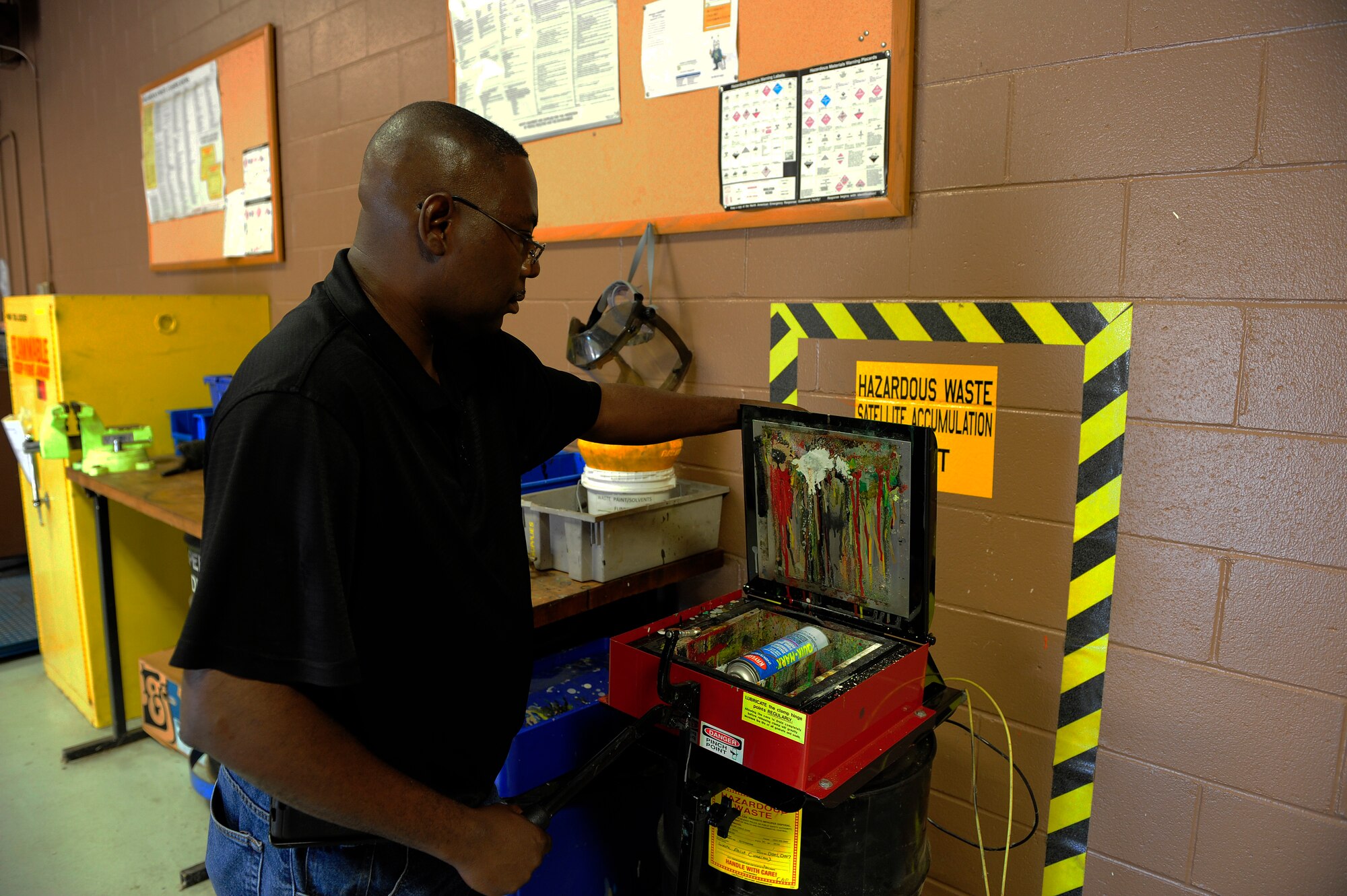 Darryl Keith, Shaw Air Force Base central accumulation point environmental technician, uses the aerosol can puncturing machine to release the pressurized gas within an aerosol can before disposing of it at Shaw AFB, S.C., Oct. 5, 2012. Because aerosol cans operate using a pressurized gas system, they pose the threat of exploding when exposed to adverse conditions. This step is performed to reduce the risk to the environment and people. (U.S. Air Force photo by Airman 1st Class Daniel Blackwell/Released)