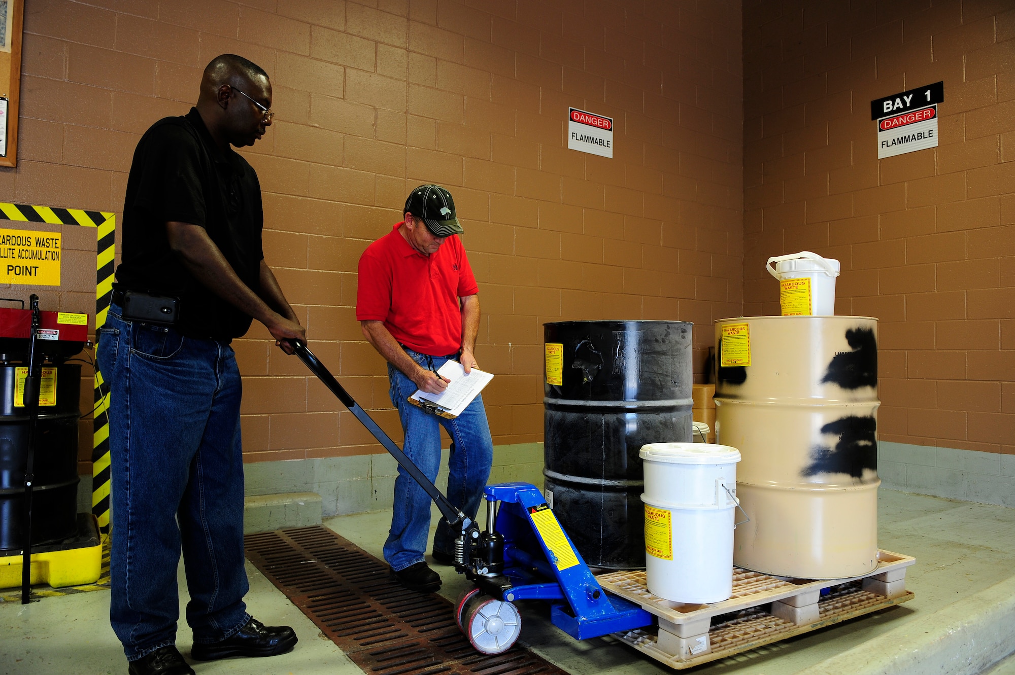 Darryl Keith (left) and Rodney Greene, Shaw Air Force Base central accumulation point environmental technicians, move and inventory hazardous items so they can be properly documented and stored before being disposed of at Shaw AFB, S.C., Oct. 5, 2012. The central accumulation point recycles otherwise unusable materials, saving the environment and citizens from their toxic effects, while also creating revenue for the government by reusing the recycled materials. (U.S. Air Force photo by Airman 1st Class Daniel Blackwell/Released)