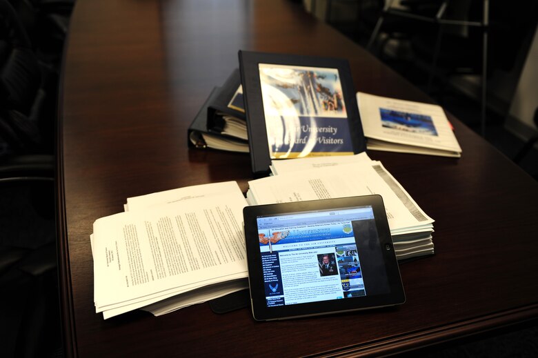 A portable computer tablet sits on top of the mountain of material it replaced. In 2011, Gen. Edward Rice Jr., Air Education and Training Command commander, challenged Airmen in the command to save $3 a day, and the tablets are one way that Maxwell Air Force Base is using technology to meet that cost conscious culture challenge. (U.S. Air Force photo by Master Sgt. Michael Voss) 