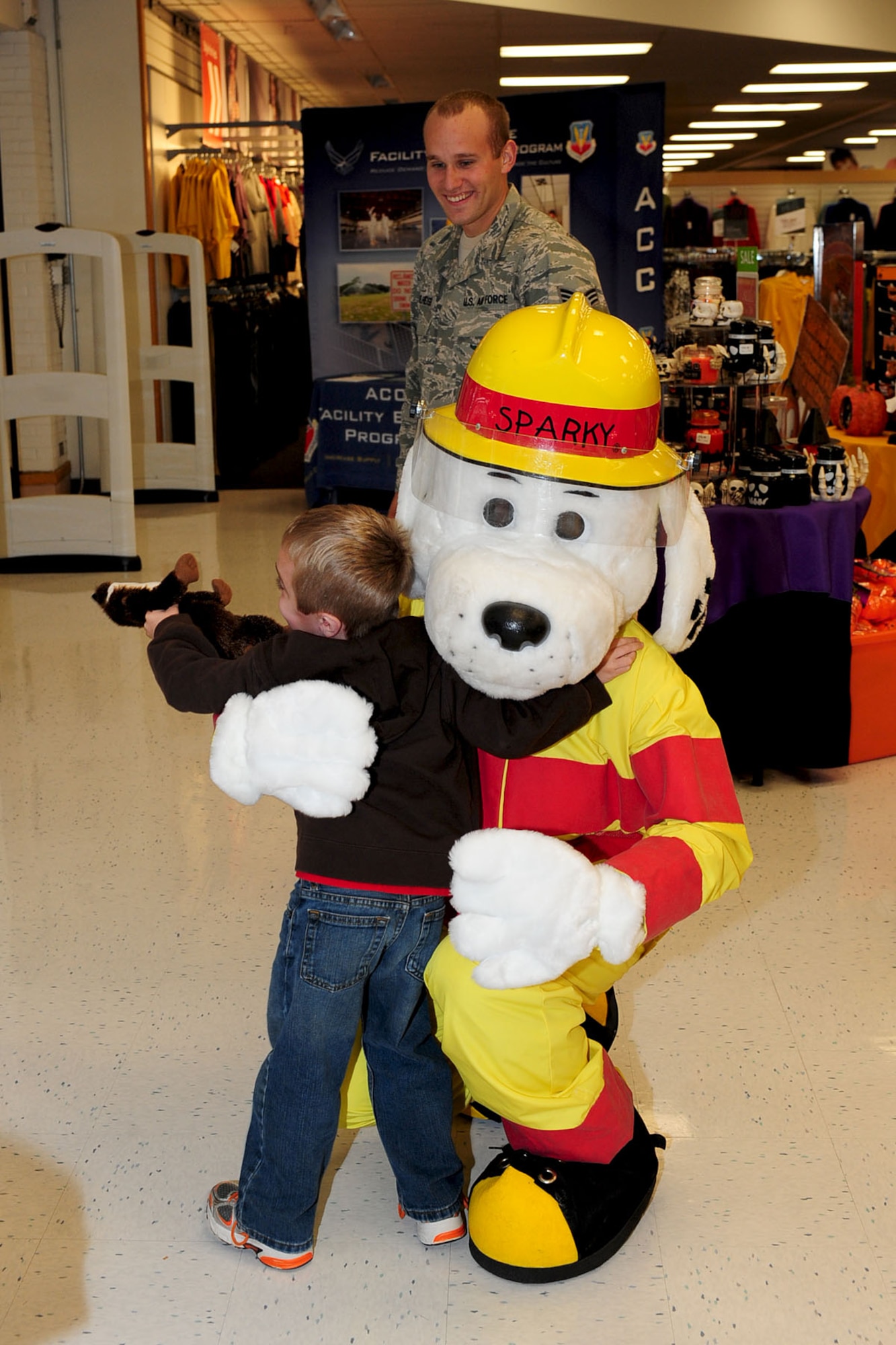 Seven-year-old Tristan Crain, son of retired Tech Sgt. Tammy Crain, hugs Sparky the Fire Dog during a Fire Prevention Week demonstration at the Base Exchange, Langley Air Force Base, Va., Oct. 9, 2012. The 633rd Civil Engineer Squadron fire department visited the BX to express fire safety tips and building evacuation to base personnel and their dependents. Oct. 8-13, 2012, is Fire Prevention Week. Be sure to check out The Peninsula Warrior Oct. 20 for continuing coverage of JBLE's firefighters in action.(U.S. Air Force photo by Staff Sgt. Ashley Hawkins/Released)