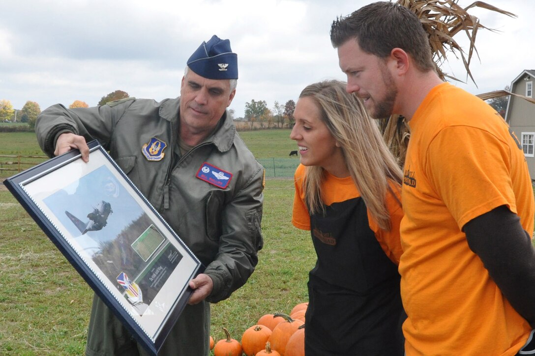 YOUNGSTOWN AIR RESERVE STATION, Ohio -- Colonel Bill Phillips, commander of the 910th Operations Group, presents Rob and Stacy Milliron a framed photo of a 910th Airlift Wing C-130 Hercules October 6.  The Millirons are owners of Millsiron Farmstead, in New Wilmington, Pa. where they grew a corn maze to honor the men and women of the 910th Airlift Wing. U.S. Air Force photo by Maj. Brent J. Davis