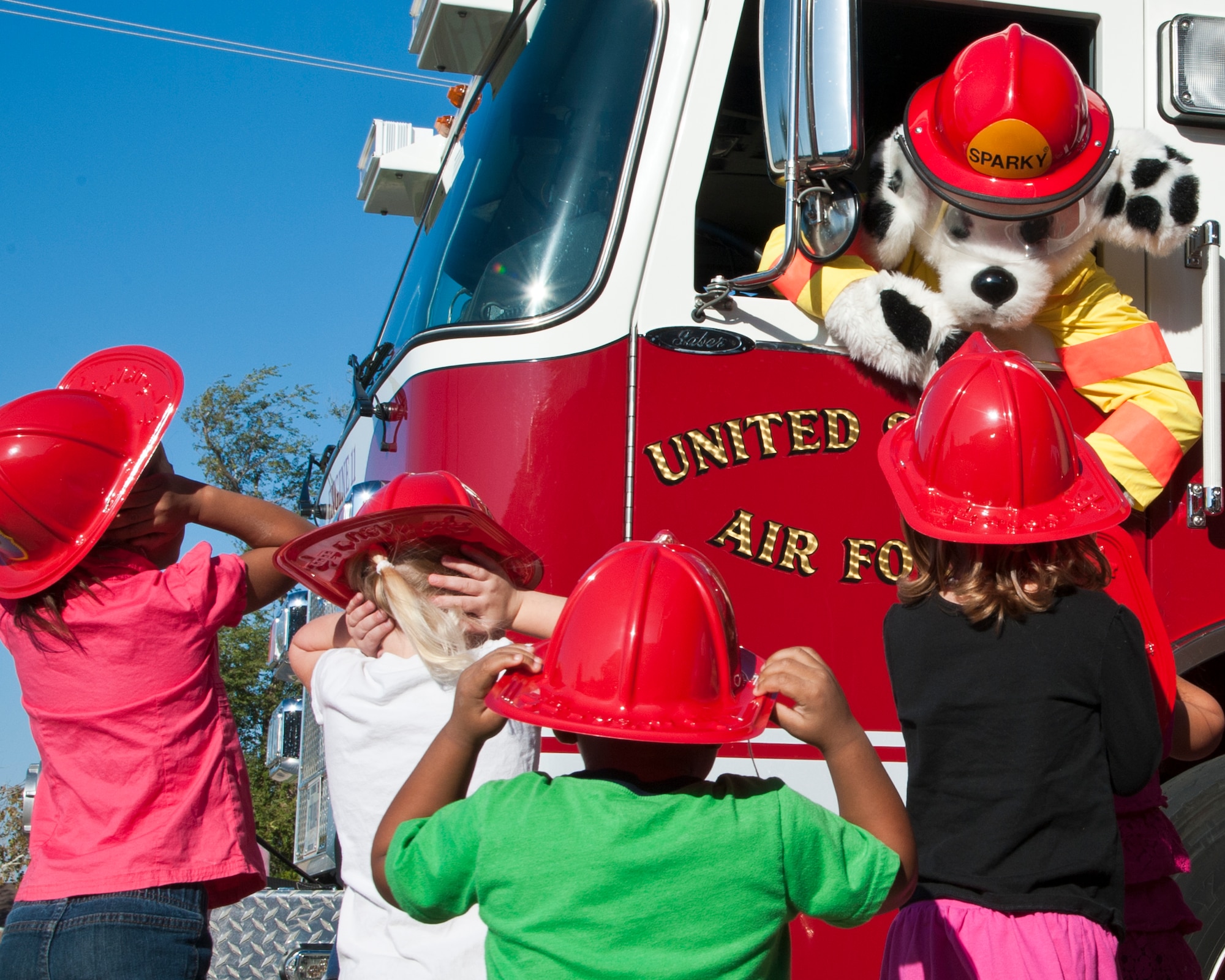 ALTUS AIR FORCE BASE, Okla. -- Sparky the fire dog from the 97th Civil Engineer Squadron fire department, interacts with children from the driver seat of a fire truck at the Child Development Center, Oct. 9, 2012. Sparky was visiting the children of the CDC to educate them about fire prevention. The week of Oct. 8-12 is known as Fire Prevention Week, during which the 97th CES fire department visits various areas of the base to promote fire prevention. (U.S. Air Force photo by Senior Airman Kenneth W. Norman / Released)