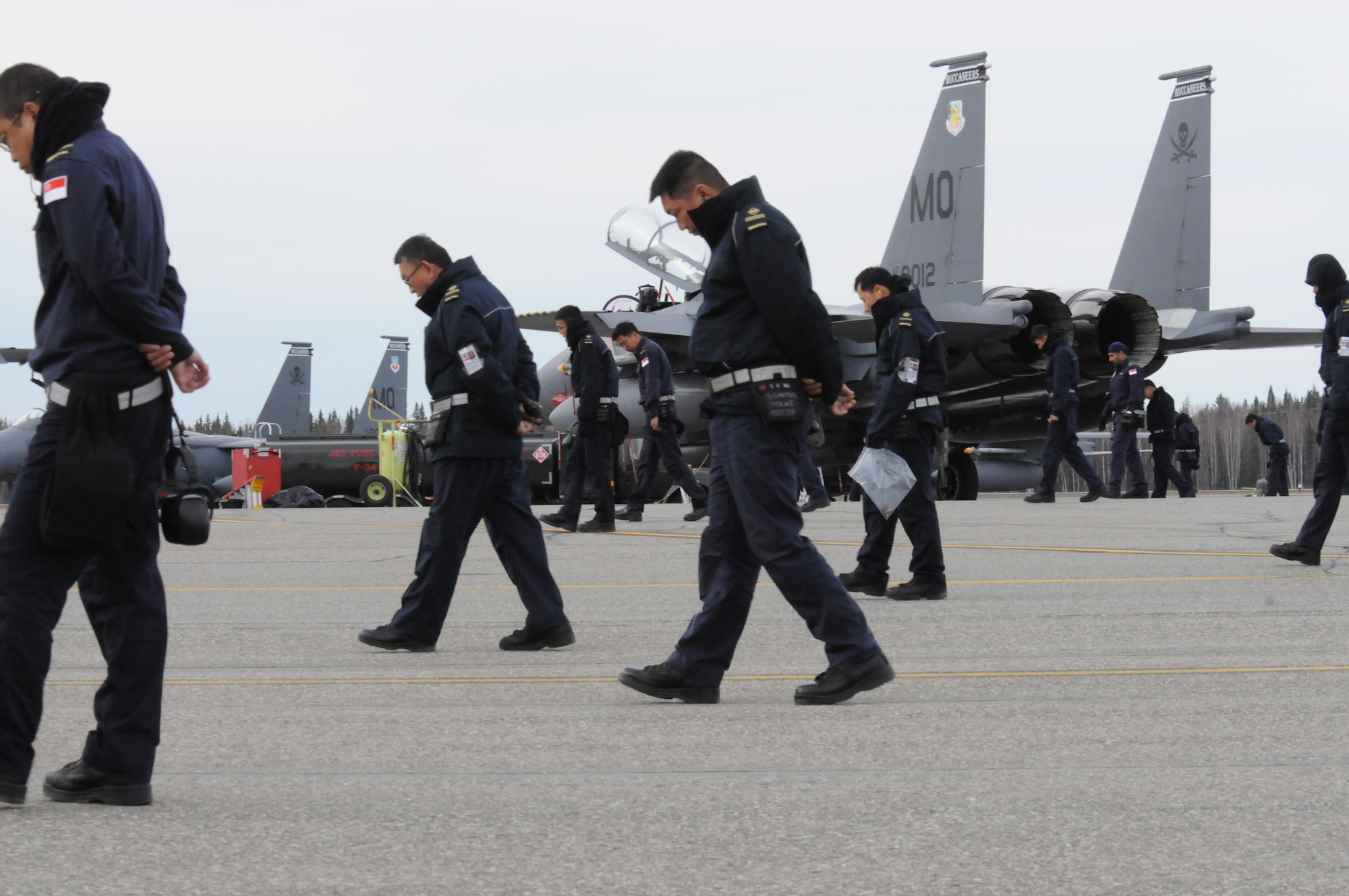 Members of the 428th Fighter Squadron perform a foreign objects and debris or FOD walk at the conclusion of their flight day Oct. 5, 2012, at Eielson Air Force Base, Alaska. The Republic of Singapore personnel are on temporary duty from Mountain Home Air Force Base, Idaho, to participate in RED FLAG-Alaska 13-1. (U. S. Air Force photo/Senior Airman Benjamin Sutton)        