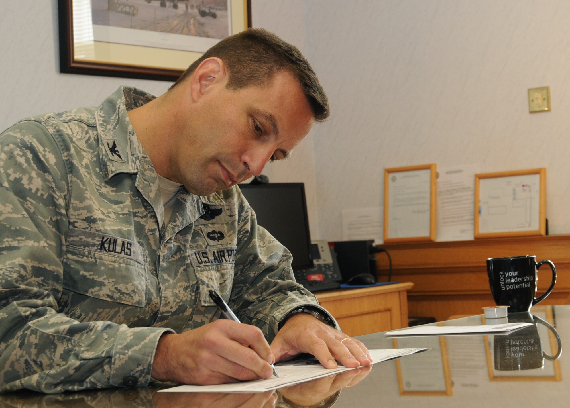 Col. Christopher Kulas, 100th Air Refueling Wing commander, signs a Combined Federal Campaign donation form Oct. 9, 2012, in his office at RAF Mildenhall, England. The CFC is a voluntary program that provides federal employees the opportunity to donate to charities through payroll deductions or a one-time payment. (U.S. Air Force photo by Tech. Sgt. Neal X. Joiner/Released) 