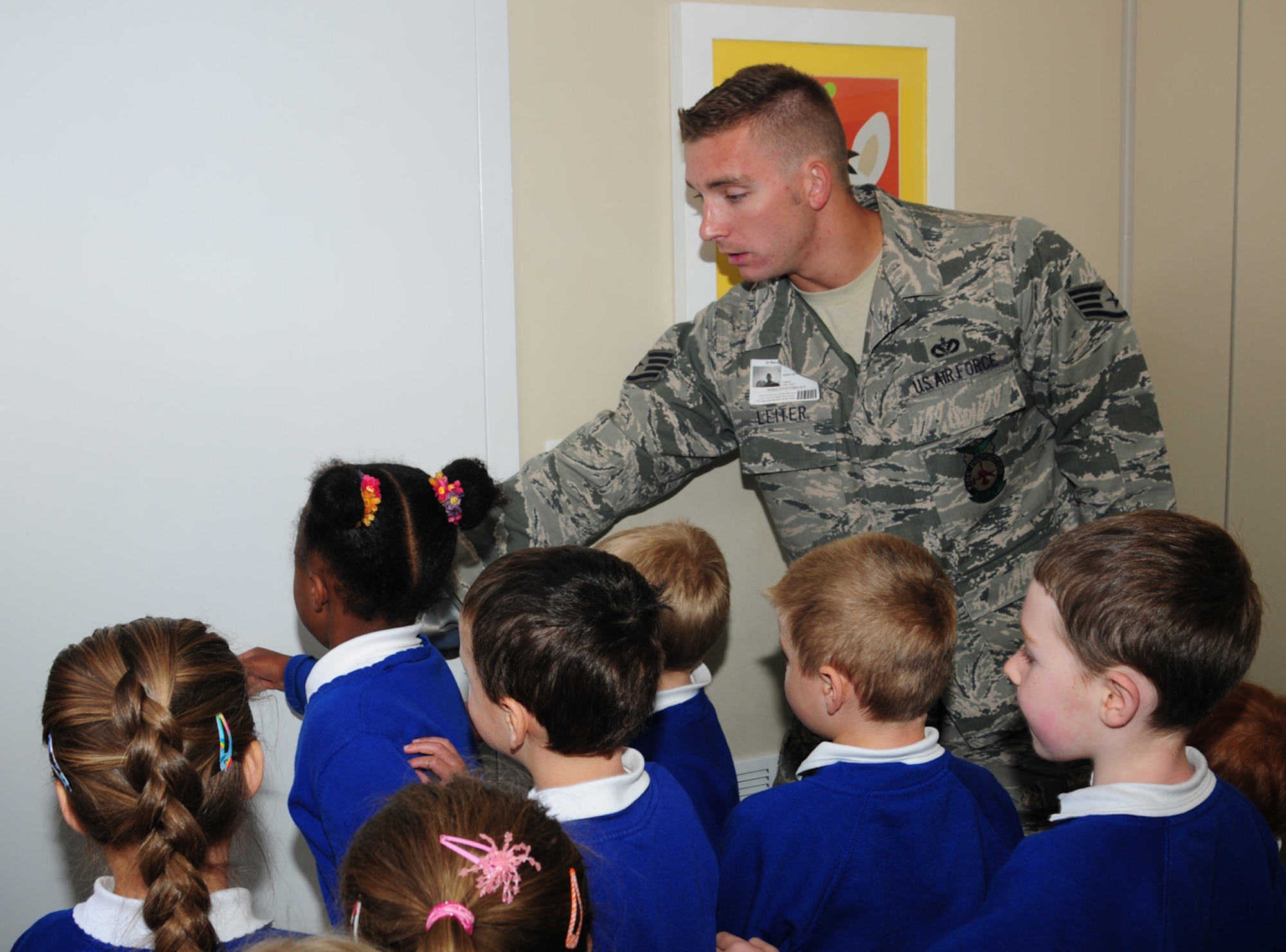 Staff Sgt. Noah Leiter, 100th Civil Engineer Squadron Fire Department firefighter, encourages children to touch a door in the fire prevention trailer with the back of their hands, to feel how warm it was, at St. Mary’s Academy, Mildenhall, Suffolk, Oct. 8, 2012. Firefighters from RAF Mildenhall brought the trailer, which is able to simulate house fires, in order to educate the children on what to do in the event of a fire. They learned that if a door is warm to the touch, they mustn’t open it, but should quickly leave the house by other means. (U.S. Air Force photo/Karen Abeyasekere)