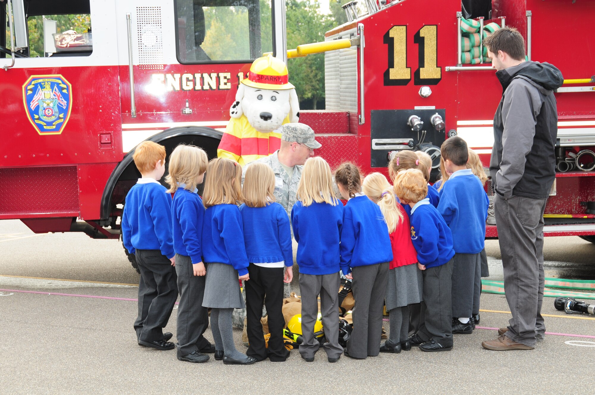 Children at St. Mary’s Academy in Mildenhall, Suffolk, gather around Sparky the Fire Dog and Staff Sgt. William Pritchett, 100th Civil Engineer Squadron Fire Department, to get a better look a firefighter’s protective clothing Oct. 8, 2012. Firefighters from RAF Mildenhall visited the school as part of Fire Prevention Week and provided the children demonstrations and information on fire safety. (U.S. Air Force photo/Karen Abeyasekere)
