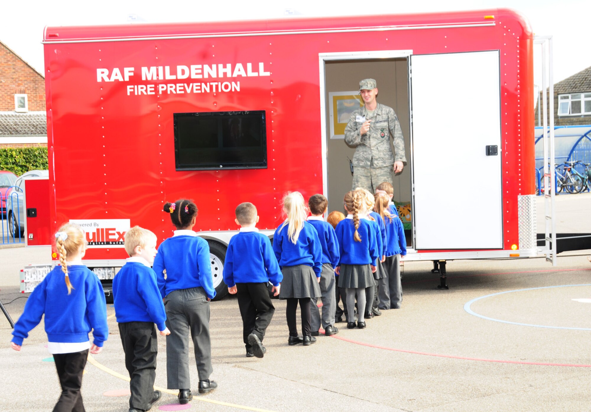 Children from St. Mary’s Academy in Mildenhall, England, wait their turn to go into the fire prevention trailer at a demonstration put on by the RAF Mildenhall Fire Department Oct. 8, 2012. The firefighters and Sparky the Fire Dog visited the school as part of Fire Prevention Week activities, to educate the children on what to do in the event of a fire. They spoke about this year’s theme, “Have two ways out”, and talked to the children about finding different ways out of the house if necessary. (U.S. Air Force photo/Karen Abeyasekere)