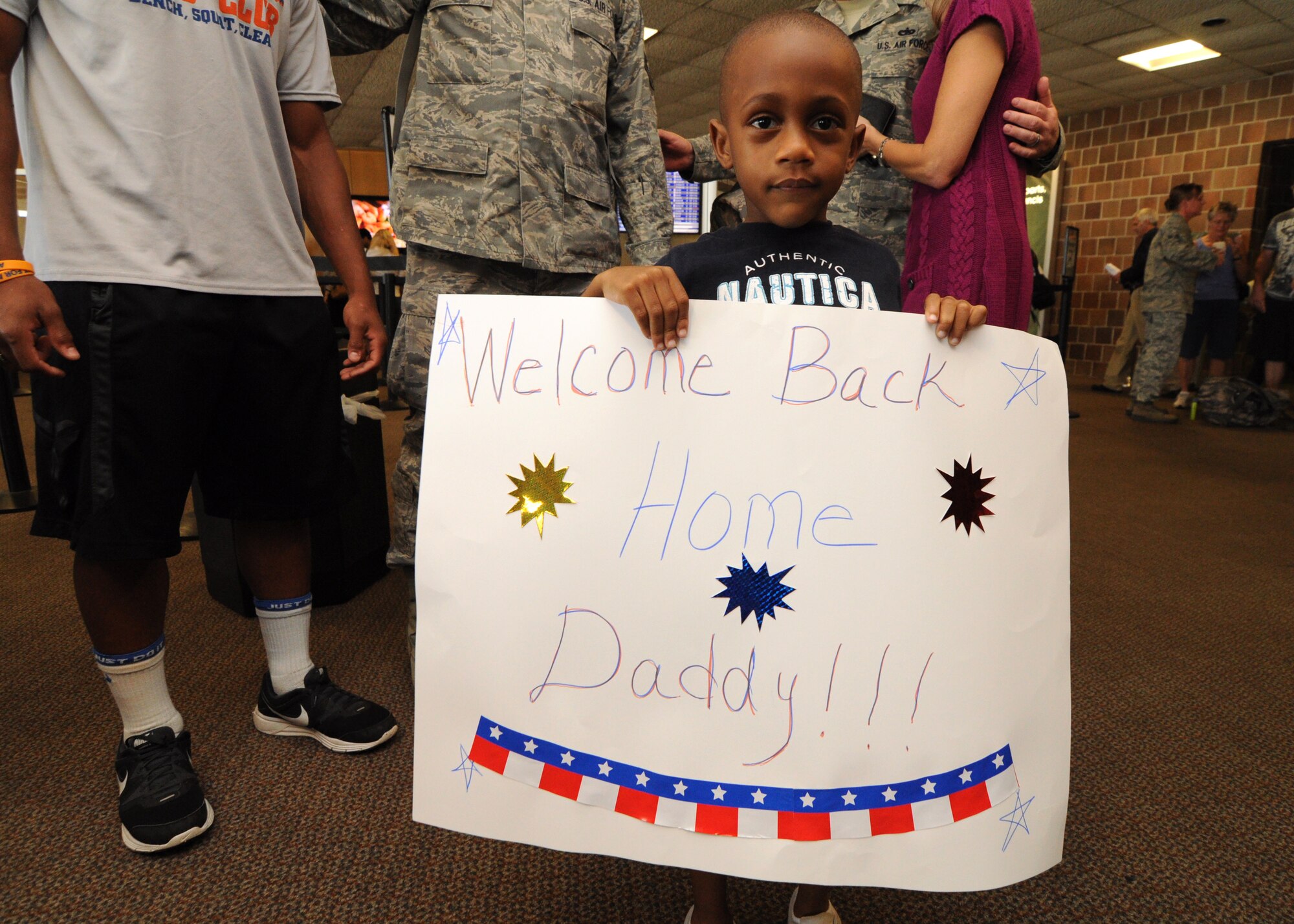 Master Sgt. Dennis Washington’s son holds a welcome home sign Oct. 6, 2012 as he awaits daddy’s return from a six-month deployment to Southwest Asia. While deployed, Washington was responsible for cargo and passenger operations at his deployed location. (U.S. Air Force Photo/Staff Sgt. Shane Ellis)