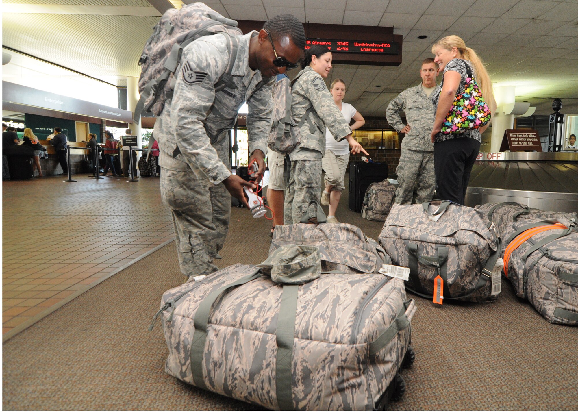 Staff Sgt. Anel Dominique gathers his luggage from the baggage terminal Oct. 6, 2012 after returning home from a six-month deployment to Southwest Asia. Dominique is one of more than 60 deployed Airmen from the 315th Airlift Wing who were responsible for cargo and passenger operations at their deployed locations. Dominique is an air transportation specialist with the 81st Aerial Port Squadron at Joint Base Charleston, S.C. (U.S. Air Force Photo/Staff Sgt. Shane Ellis)