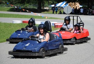 Soldiers and family members race around the go-kart track at the Fort Eustis mini-park Aug. 17, 2012. The go-kart track is one of several attractions, including mini-golf and batting cages, at the mini-park, which can be rented to group and unit functions through the fall and winter season. (U.S. Air Force photo by Senior Airman Jason J. Brown/Released)