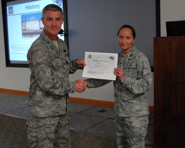 Col. John Pearse, 8th Fighter Wing commander, presents Capt. Morgan Engling, 8th Fighter Wing Judge Advocate chief of civil law, with the Pride of the Pack award Oct. 4, 2012, at Kunsan Air Base, Republic of Korea. Engling’s actions helped save a woman from her abusive husband. (U.S. Air Force photo/Capt. Sheila Johnston)  