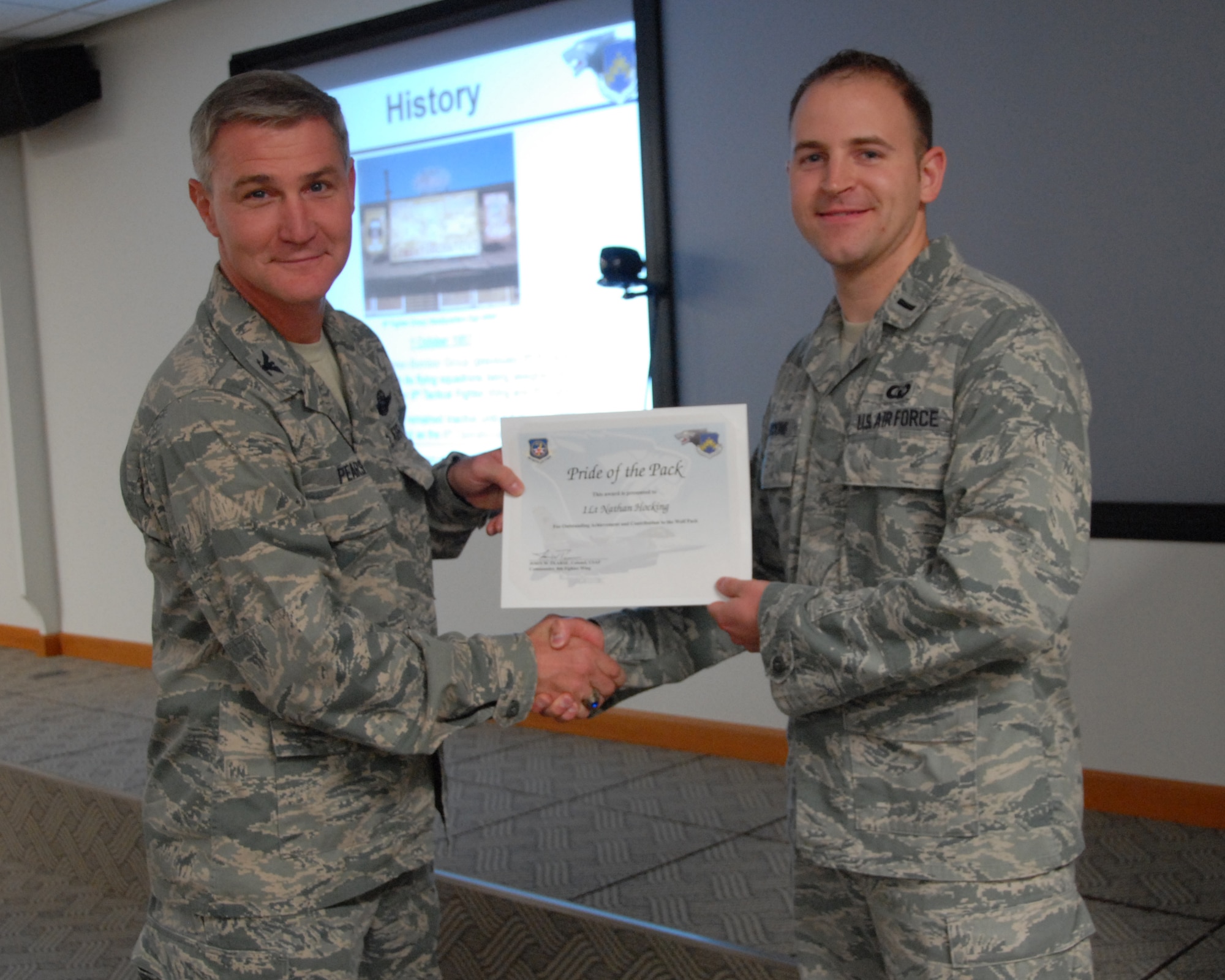Col. John Pearse, 8th Fighter Wing commander, presents 1st Lt. Nathan Hocking, 8th Operations Support Squadron airfield operations flight director of operations, with the Pride of the Pack award Oct. 4, 2012, at Kunsan Air Base, Republic of Korea. Hocking acted quickly to ensure his Wingman stayed safe while helping a friend save a woman from her abusive husband. (U.S. Air Force photo/Capt. Sheila Johnston)  