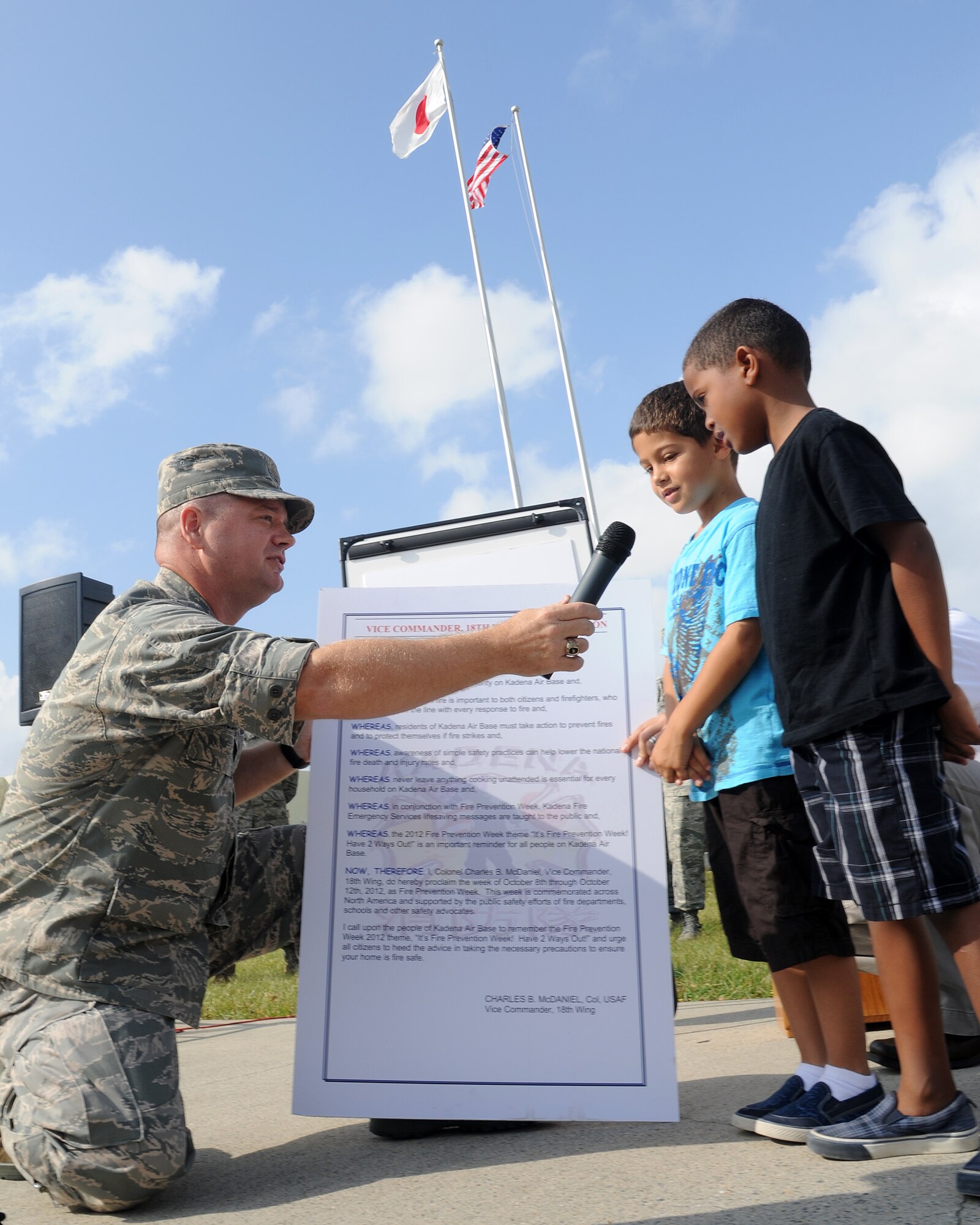 U.S. Air Force Col. Brian McDaniel, 18th Wing vice commander, asks two students from Bob Hope Primary School and Amelia Earhart Intermediate School about the "Have Two Ways Out" theme for the 2012 Fire Prevention Week at Kadena Air Base, Japan, Oct. 9, 2012. The week's theme helped remind students and base residents to always have two planned escape routes in case of a fire. (U.S. Air Force photo/ Staff Sgt. Laszlo Babocsi)