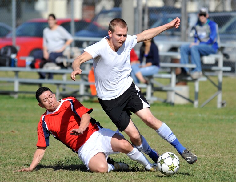Jeffrey Catton, 35th Logistics Readiness Squadron soccer team member, is tripped up by a 35th Aircraft Maintenance Squadron defender during the intramural soccer championship at Misawa Air Base, Japan, Oct. 7, 2012. The 35 LRS came out on top of the 35 AMXS 2-1 after making a penalty kick with two minutes left to play in the game. (U.S. Air Force photo by Airman 1st Class Zachary Kee)