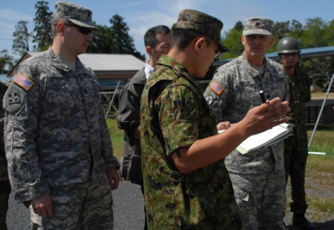 The Japan Ground Self-Defense Force staff briefs Lt. Col. James C. Horton Jr., the deputy commander of the Japan Engineer District, and Capt. Thomas Douglas, JED's Forward Engineer Support Team leader, on equipment displayed at the JGSDF's Engineer School at Camp Katsuta in Ibaraki Prefecture.