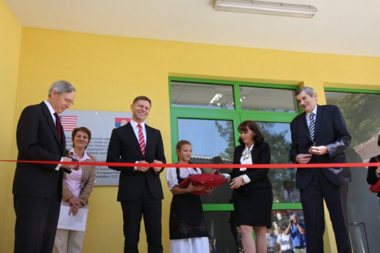Representatives from the U.S. European Command, U.S. Embassy Belgrade, U.S. Army Corps of Engineers Europe District, Serbian government and the local community celebrate the completion of the Ivo Andric Primary School sports gymnasium in Pranjani September 24, 2012 with a ribbon-cutting ceremony. The EUCOM funded and USACE managed humanitarian assistance project included a 1,580-square-meter sports gymnasium with locker room facilities. The gym was originally started by the municipality, but never completed due to lack of funding. The project also included the installation of indoor bathroom facilities and general renovations to the existing building (new flooring, exterior doors and windows, entry canopy and paint). The project was completed in the town of Pranjani as a small token of thanks. During World War II more than 500 airmen were shot down over occupied Serbia and rescued by by local Serbians who ultimately assisted in the largest evacuation of troops behind enemy lines in history. The people of Pranjani were instrumental in the success of the Halyard Mission rescue, building an airstrip to enable the evacuation. Through partnership and the successful completion of this project the people of the U.S. and Serbia continue to cultivate their friendship.