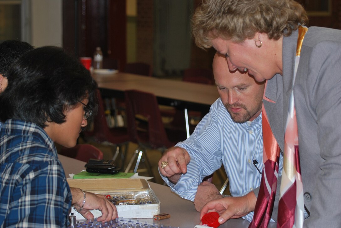 Peggy Grubbs, Fort Worth District Deputy Engineer and James B. Miller, the District's Emerging Leader work with 9th grader Matthew Ramirez, 14 to complete a circuit during a Great Minds In STEM event at Highland High School in San Antonio, Texas September 26.