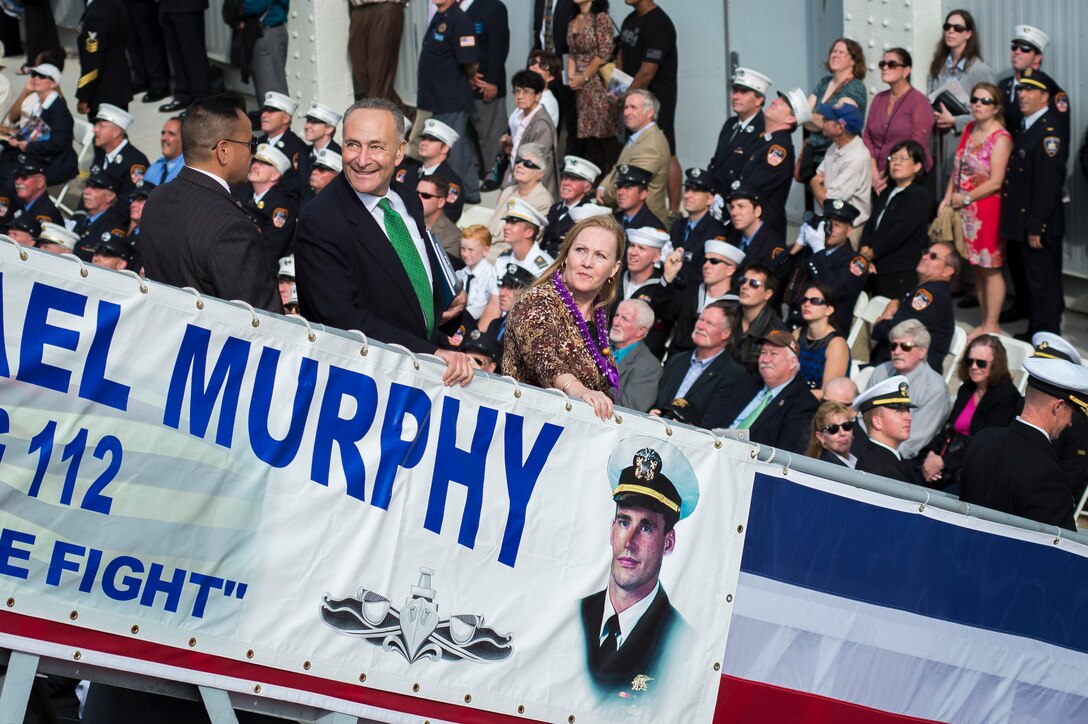 Maureen Murphy, mother of Navy Lt. Michael Murphy and the sponsor of the ship bearing her son's name, and U.S. Sen. Charles E. Schumer of New York look back at the USS Michael Murphy as a military helicopter performs a flyover at the end of the ship's commissioning ceremony in New York, Oct. 6, 2012. 
