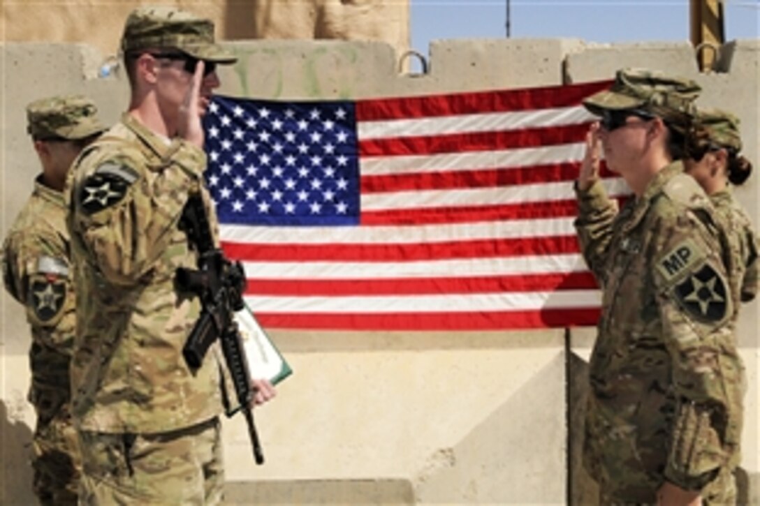 U.S. Army Staff Sgt. Rebecca Osborn, right, re-enlists during a ceremony on Forward Operating Base Spin Boldak, Afghanistan, Oct. 7, 2012. Osborn, a military police officer, is assigned to the 2nd Infantry Division's 5th Battalion, 20th Infantry Regiment, 3rd Stryker Brigade Combat Team.