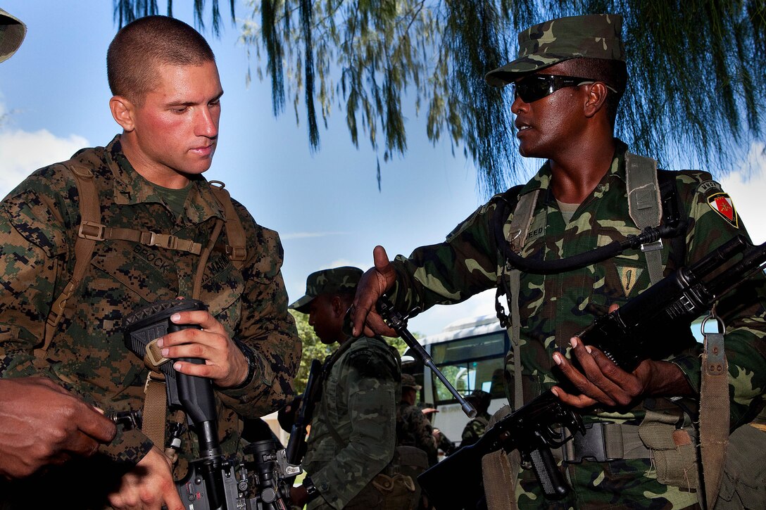 GAN, Republic of Maldives - A rifleman with Marine Deployment Unit 5, Maldivian National Defense Force, teaches a U.S. Marine about the AK-47, the standard rifle used in the MNDF. Service members from the U.S. and Republic of Maldives exchanged knowledge here Oct. 6, as part of Exercise Coconut Grove 2012. Coconut Grove is a bilateral training exercise conducted bi-annually between the U.S. Marine Corps and the MNDF.