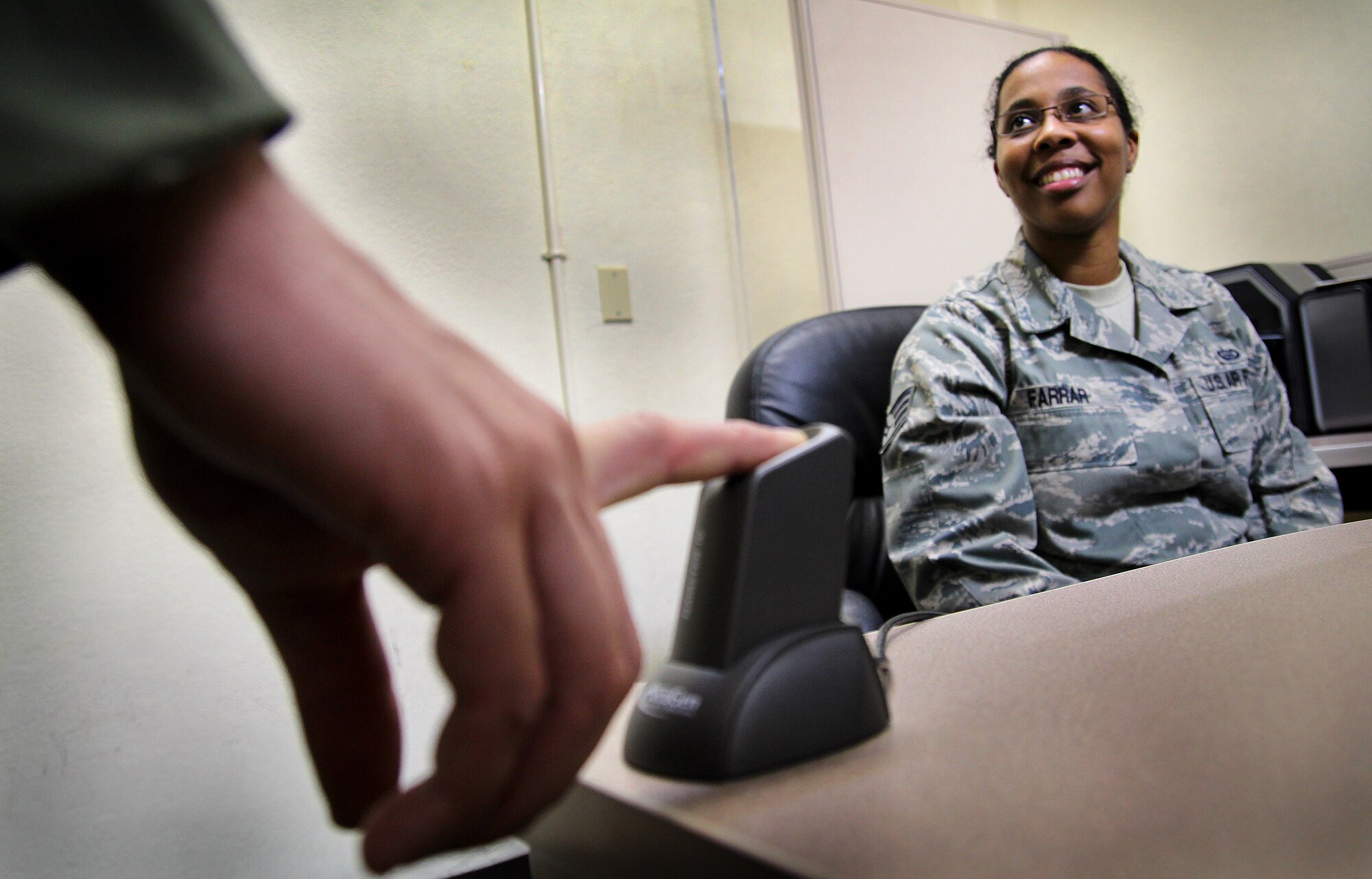 Staff Sgt. April Farrar, 18th Forces Support Squadron assistant NCO in charge of the Military Personnel Section customer service, registers the fingerprint of a customer while creating a new ID card on Kadena Air Base, Japan, Oct. 10, 2012. Every second and fourth Wednesday of the month, the MPS offers walk-in customer service from 8 a.m. to 8 p.m. to accomodate customers with atypical work schedules. (U.S. Air Force photo/Tech. Sgt. Jason Lake)
