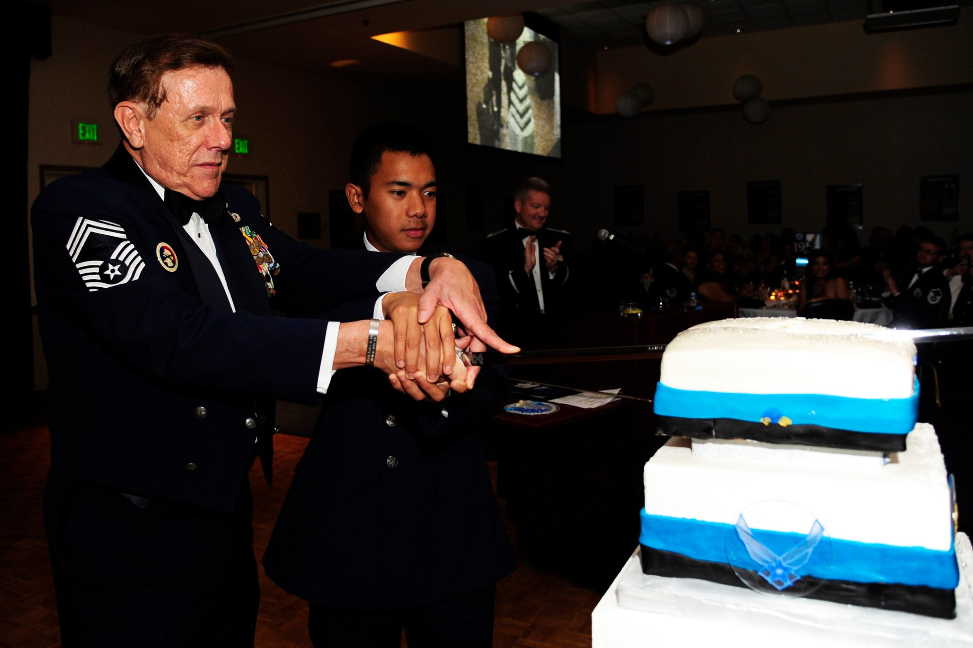 VANDENBERG AIR FORCE BASE, Calif. – Retired Chief Master Sgt. Norm Marous, Joint Retired Members Center director, makes the first ceremonial cut of the cake with Airman Basic Ferdie Galicia, 532nd Training Squadron student, during the Air Force Ball here Friday, Oct. 5, 2012. It is tradition for the oldest enlisted member and the youngest to cut the cake with a sword at a birthday celebration. The AF Ball celebrated the 65th birthday of the AF and the 30th anniversary of the AFSPC. (U.S. Air Force photo/Senior Airman Lael Huss)