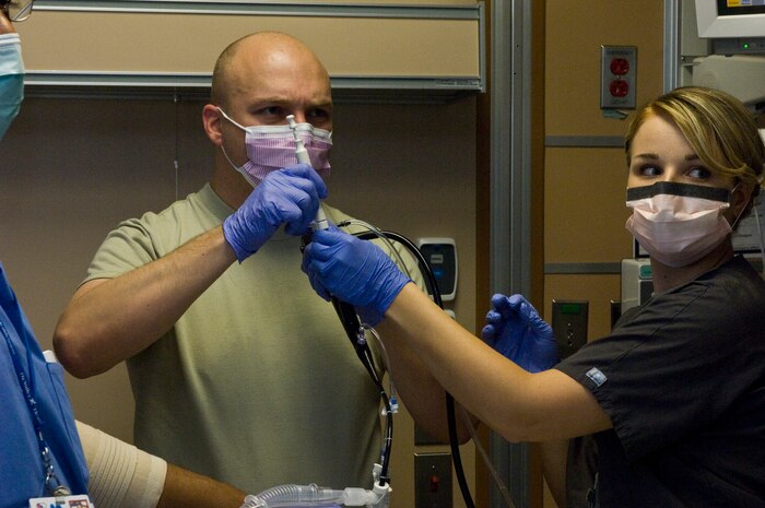 Maj. (Dr.) Jeremy Kilburn, 99th Medical Operations Squadron cardiopulmonary flight commander and Intensive Care Unit director, positions a needle for biopsy of a mass in the lungs of a patient with the Endobronchial Ultrasound Broncialscope as Senior Airman Danielle Thinnes, 99th Medical Operations Squadron cardiopulmonary technician steadies the Endobronchial Ultrasound Broncialscope Oct. 4, 2012, at Nellis Air Force Base, Nev. The Endobronchial Ultrasound Bronchialscope procedure is a newer procedure to the medical center provides a less invasive approach that can provide quicker results to patients as well as being more cost efficient. (U.S. Air Force photo by Senior Airman Jack Sanders)