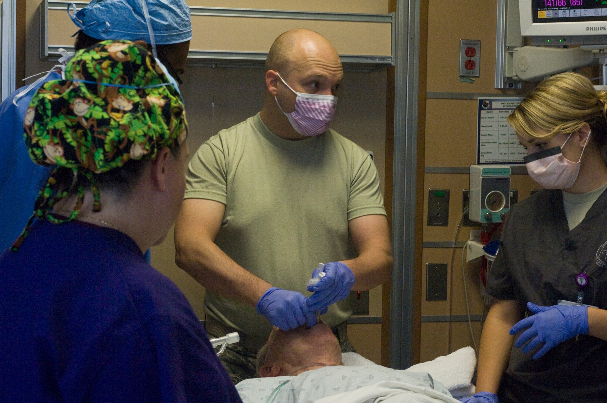 Maj. (Dr.) Jeremy Kilburn, 99th Medical Operations Squadron Cardiopulmonary Flight commander and Intensive Care Unit director, begins an Endobronchial Ultrasound Broncialscope, while explaining the next step of the procedure to Senior Airman Danielle Thinnes, 99th MDOS cardiopulmonary technician, Oct. 4, 2012, at Nellis Air Force Base, Nev. The Endobronchial Ultrasound Broncialscope procedure is a new procedure at the Mike O?Callaghan Federal Medical Center. The procedure is less invasive than traditional surgery and can provide quicker results to patients, as well as being more cost efficient. (U.S. Air Force photo by Senior Airman Jack Sanders)