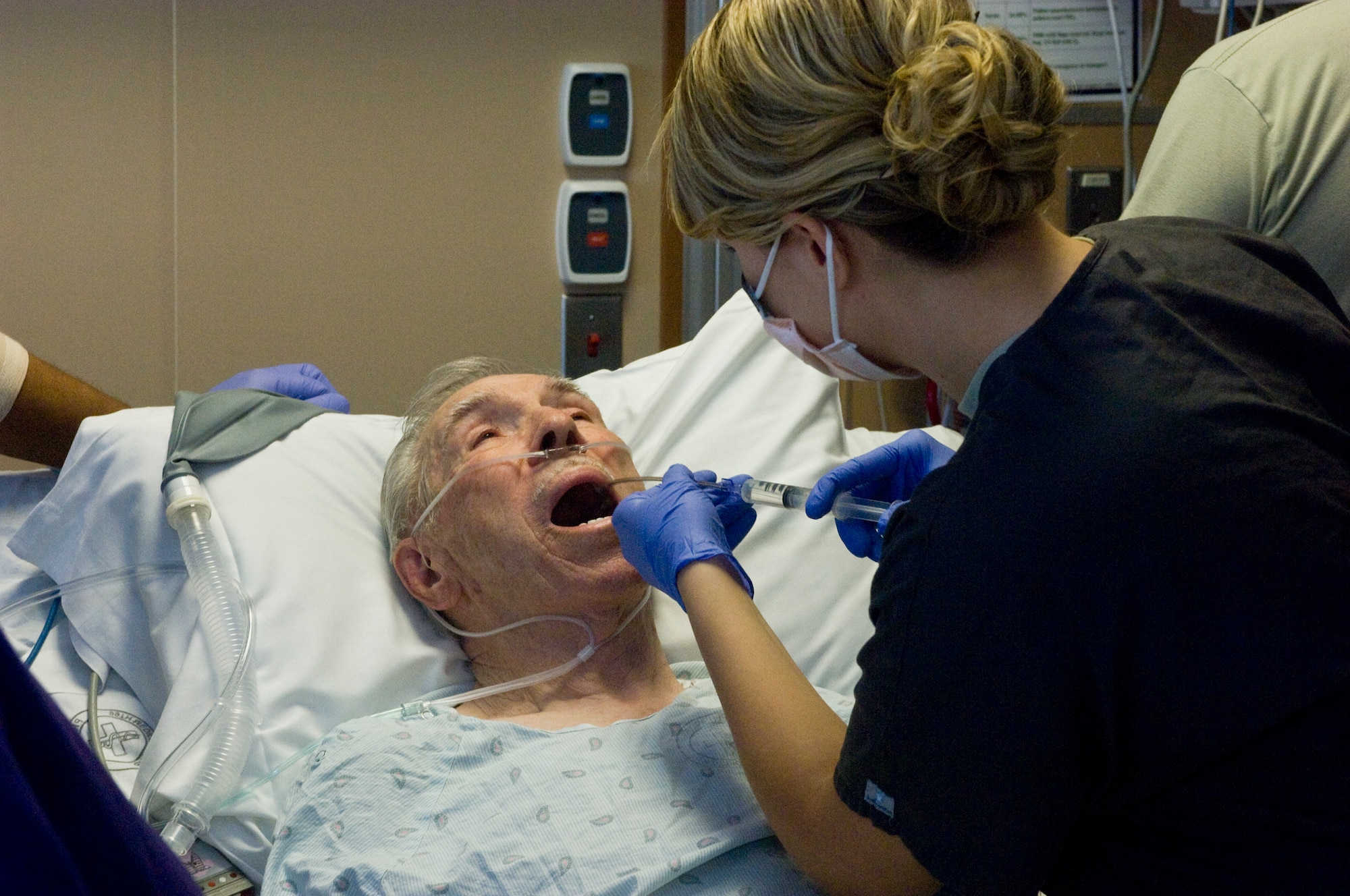 Senior Airman Danielle Thinnes, 99th Medical Operations Squadron cardiopulmonary technician, administers a numbing agent to the back of Davis Leonard?s throat before an Endobronchial Ultrasound Broncialscope Oct. 4, 2012, at Nellis Air Force Base, Nev. Leonard, a patient at the Mike O?Callaghan Federal Medical Center, underwent the procedure to get a faster test result on a mass in his lung to determine if it was cancerous. (U.S. Air Force photo by Senior Airman Jack Sanders)
