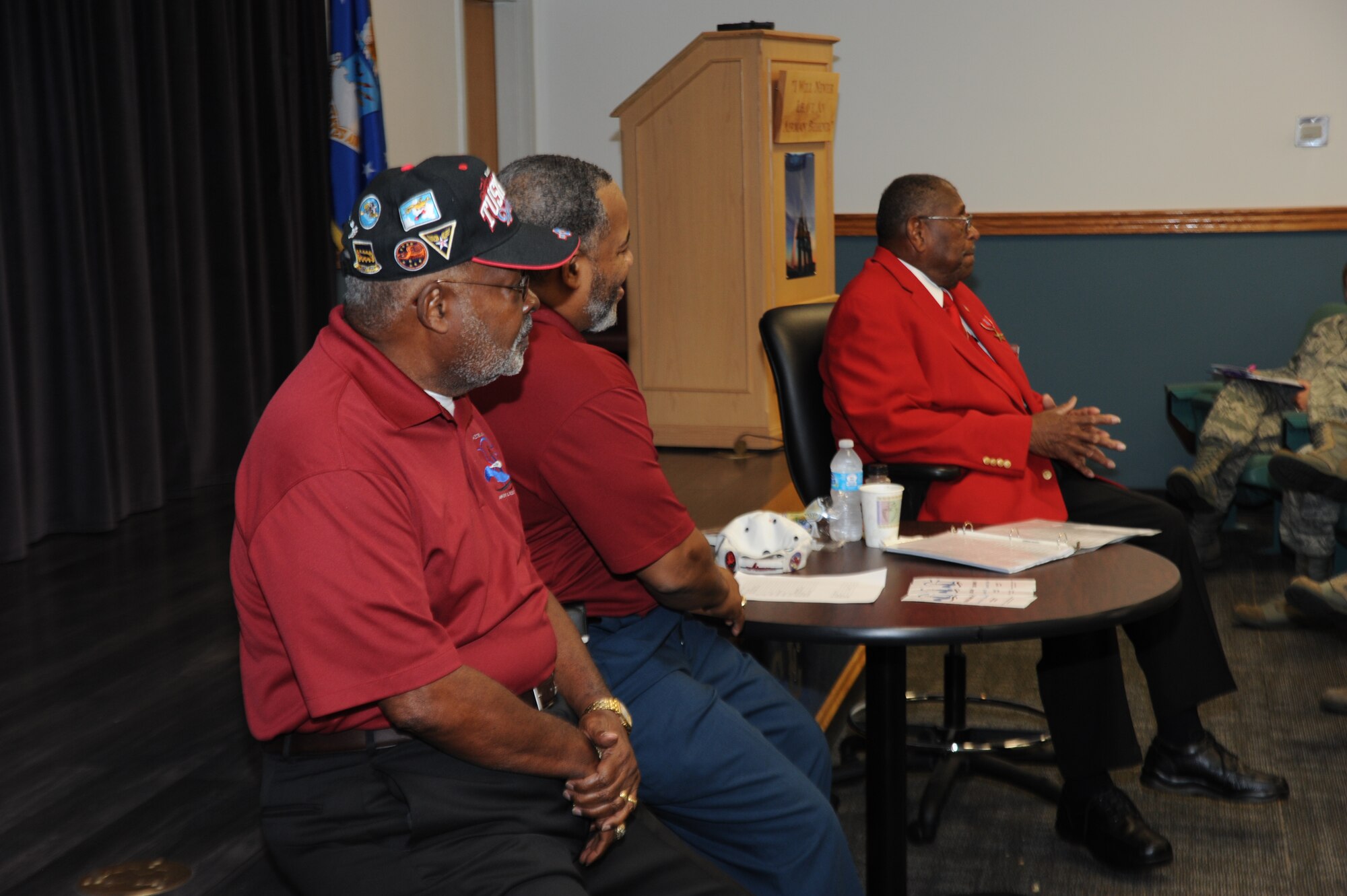 Charles Bowers and retired Chief Master Sgt. Curtis Jennings, watch retired Chief Master Sgt. Walter Richardson, a Tuskegee Airman and Congressional Gold Medal recipient, as he speaks to students Oct. 4 at the Mathies Noncommissioned Officer Academy. Richardson shared with the students his experience as one of 1,500 African-American Airmen selected to integrate the Air Force in 1949.  (U.S. Air Force photo by Staff Sgt. Eric Summers)