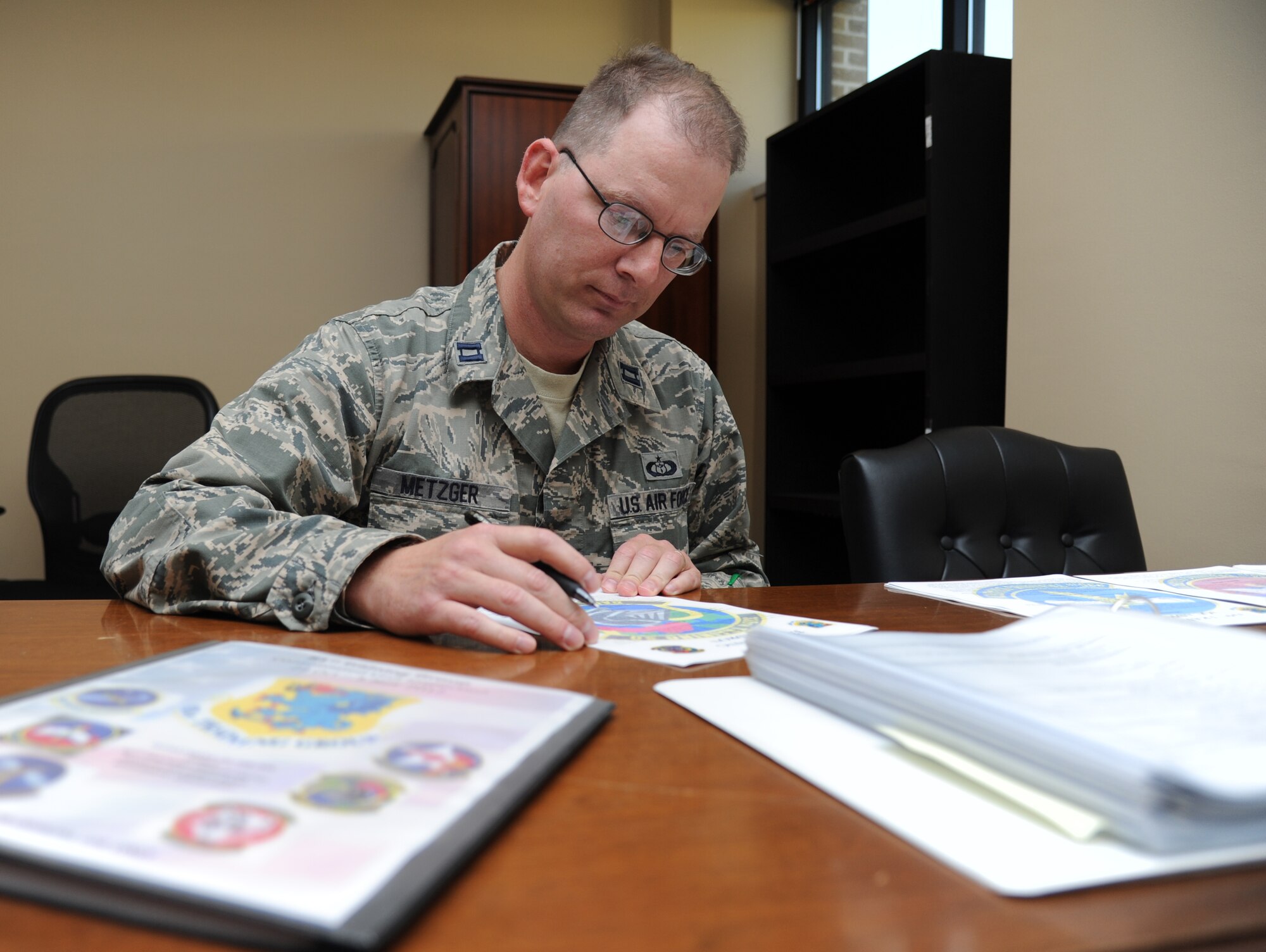 Capt. Eric Metzger, 335th Training Squadron instructor supervisor for the advanced weather courses, temporarily assigned to the 81st Training Group combined unit inspection preparation lead, edits group level brag books Oct. 5, 2012, at Matero Hall, Keesler Air Force Base, Miss.  Metzger’s masters thesis paper is scheduled to be published in the American Meteorological Society’s Journal of Weather and Forecasting.  (U.S. Air Force photo by Kemberly Groue)
