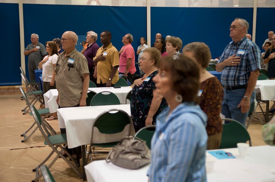Retirees stand for the national anthem at Retiree Appreciation Day at Moody Air Force Base, Ga., Oct. 6, 2012. During the day, retirees and their families received new identification cards, a tour of static displays and played bingo.  (U.S. Air Force photo by Airman 1st Class Paul Francis/Released) 

