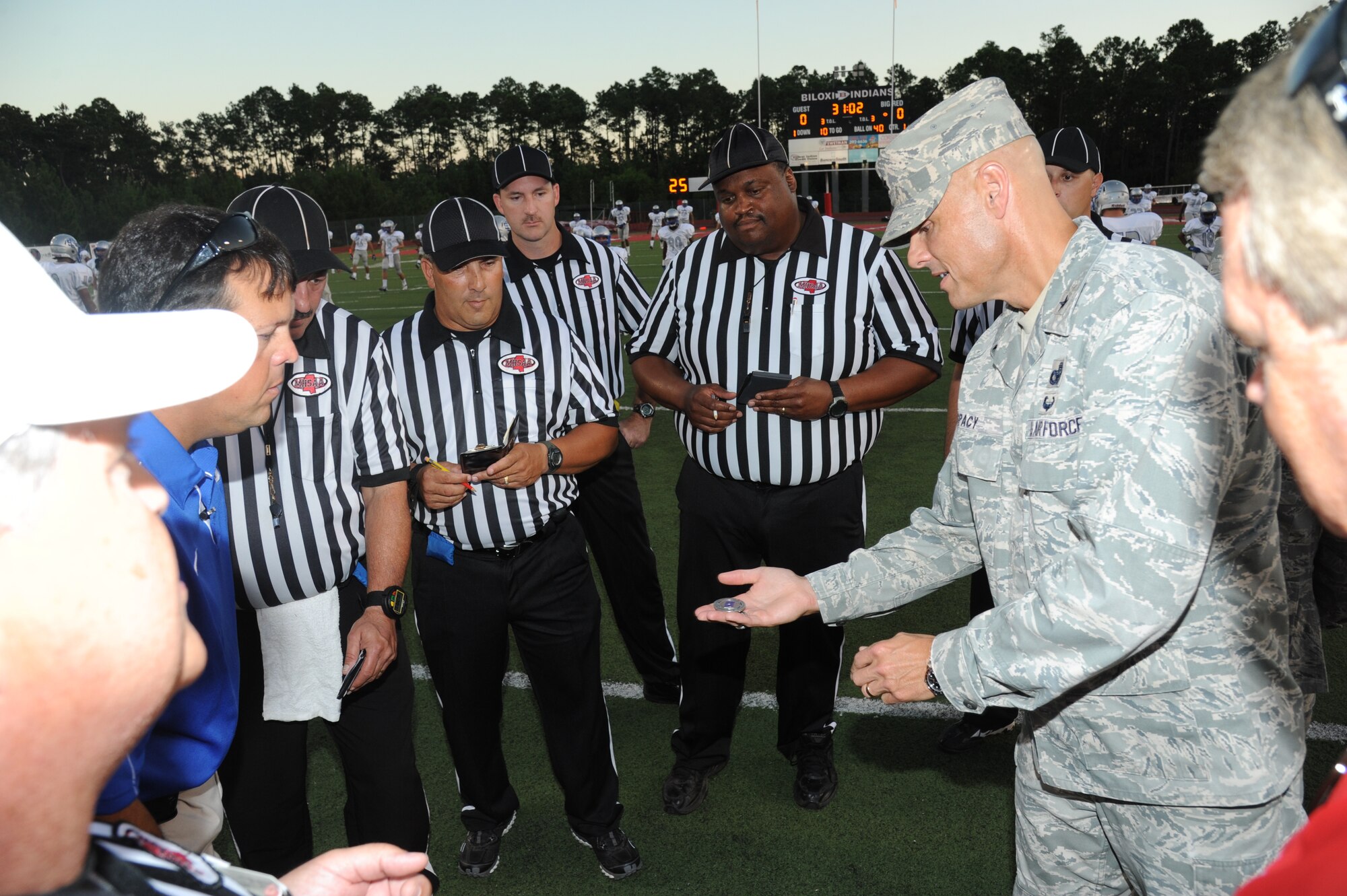Brig. Gen. Brad Spacy, 81st Training Wing commander, displays a wing coin that he prepares to flip to the referee staff and head coaches prior to the Biloxi High School football game against Ocean Springs High School Oct. 5, 2012, at the Biloxi football stadium. Spacy tossed the coin to determine which team would receive the ball first.  Ocean Springs defeated Biloxi 35-34.  (U.S. Air Force photo by Kemberly Groue)