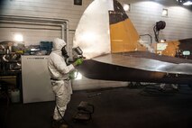 HANSCOM AIR FORCE BASE, Mass. – Frederick Smith paints part of the P-40 in the motor pool bay Sept. 25. After restoration is complete, the static display aircraft will be returned to the pedestal at the corner of Marrett Street and Vandenberg Drive. (U.S. Air Force photo by Rick Berry)