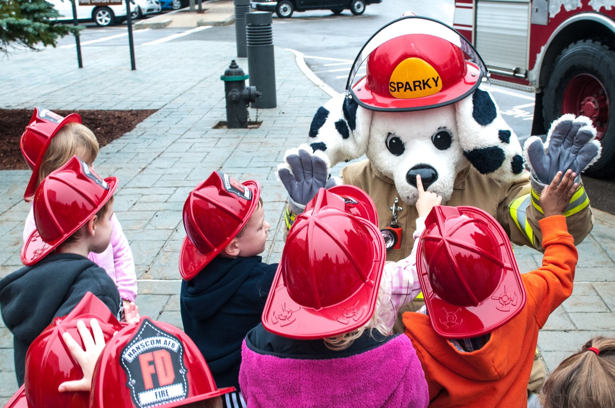 HANSCOM AIR FORCE BASE, Mass. – Children at the Child Development Center greet Sparky, the Hanscom Fire Department mascot, during a Fire Prevention Week event Oct. 10. Fire Prevention Week is observed Oct. 7 through 13 and will wrap up with a Fire Prevention Walk at Castle Park Oct. 13 from 11 a.m. to 3 p.m. (U.S. Air Force photo by Rick Berry)